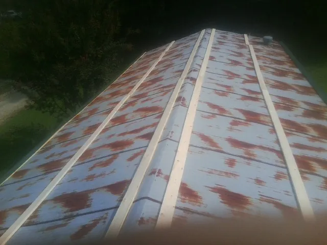 Rusted metal roof panels with new wood purlins before replacement — Storm Damage Roof Repair in Martinsburg by Roofing Brothers