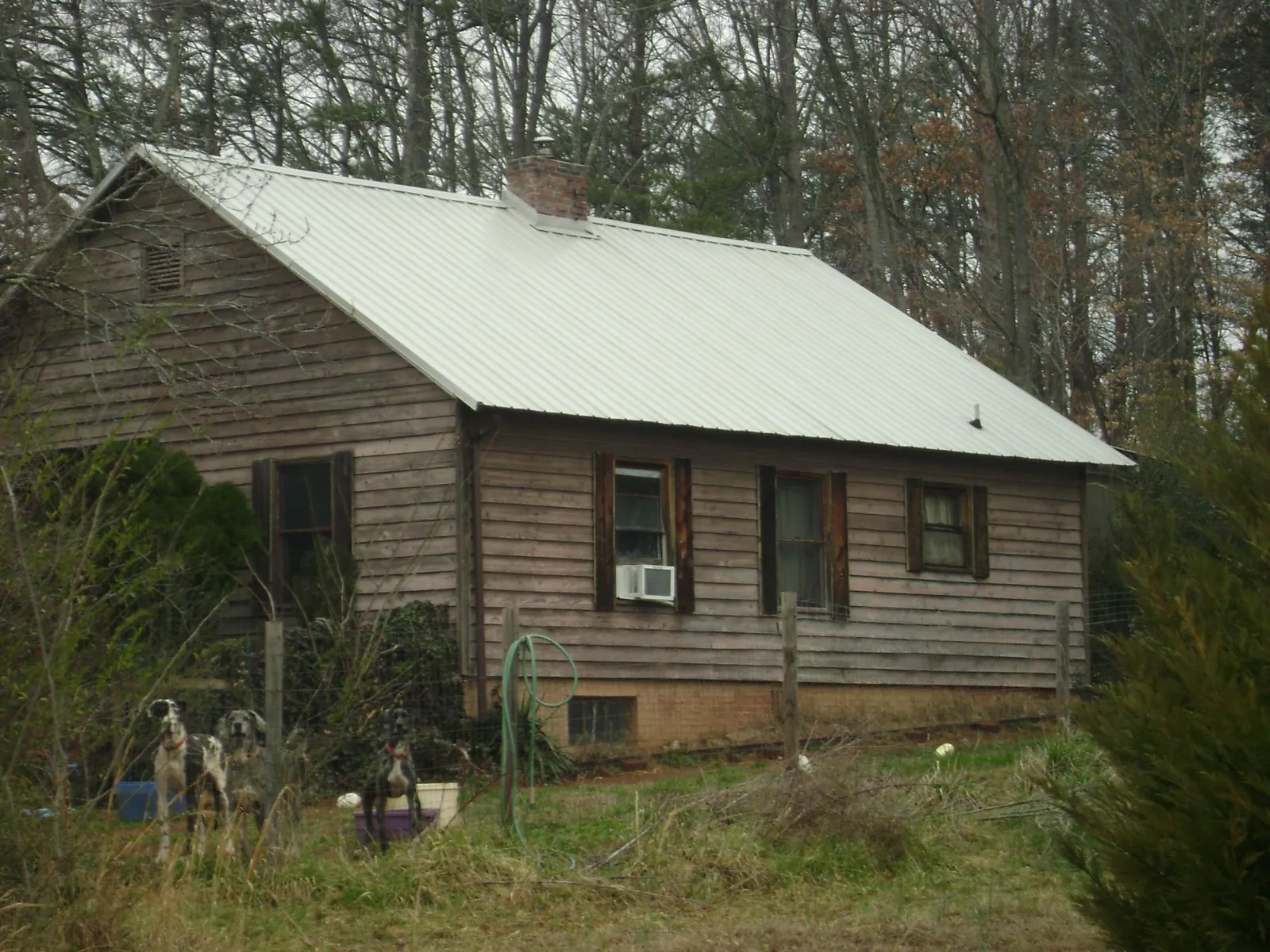 White metal roof on an old wood sided farmhouse, from a Metal Roof Installation job in Martinsburg